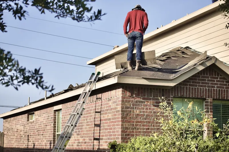 Professional roofer working on a residential roof in Upper Milford